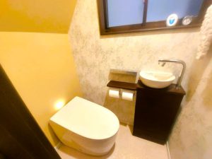 シャープなデザインのタンクレストイレをセレクト　手洗い器を設置し衛生面も重視　既存窓枠とキャビネットカラーを統一したことで洗練された空間になりました